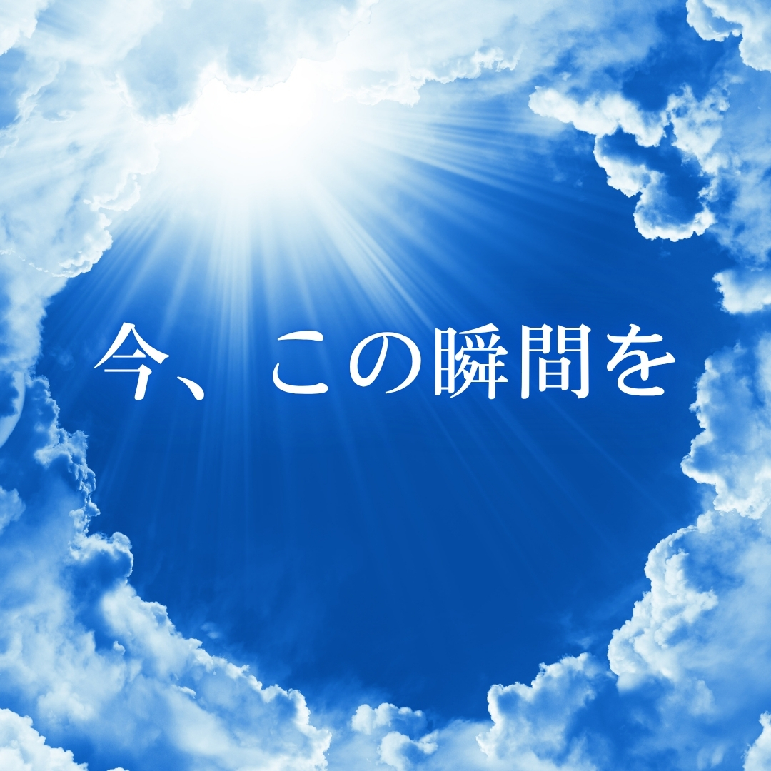 雲の切れ間から青空と太陽光が差し込み、「今、この瞬間を」と白文字で書かれたデザイン画像。